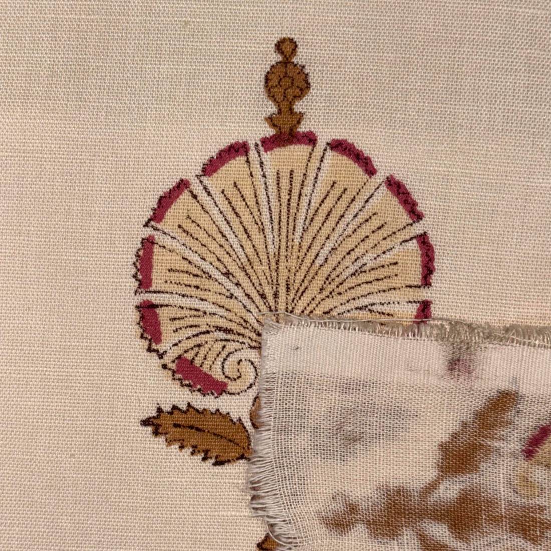 Close-up of an embroidered design on fabric with a fan-like pattern.