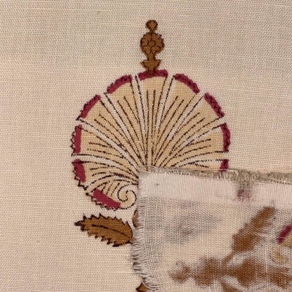 Close-up of an embroidered design on fabric with a fan-like pattern.
