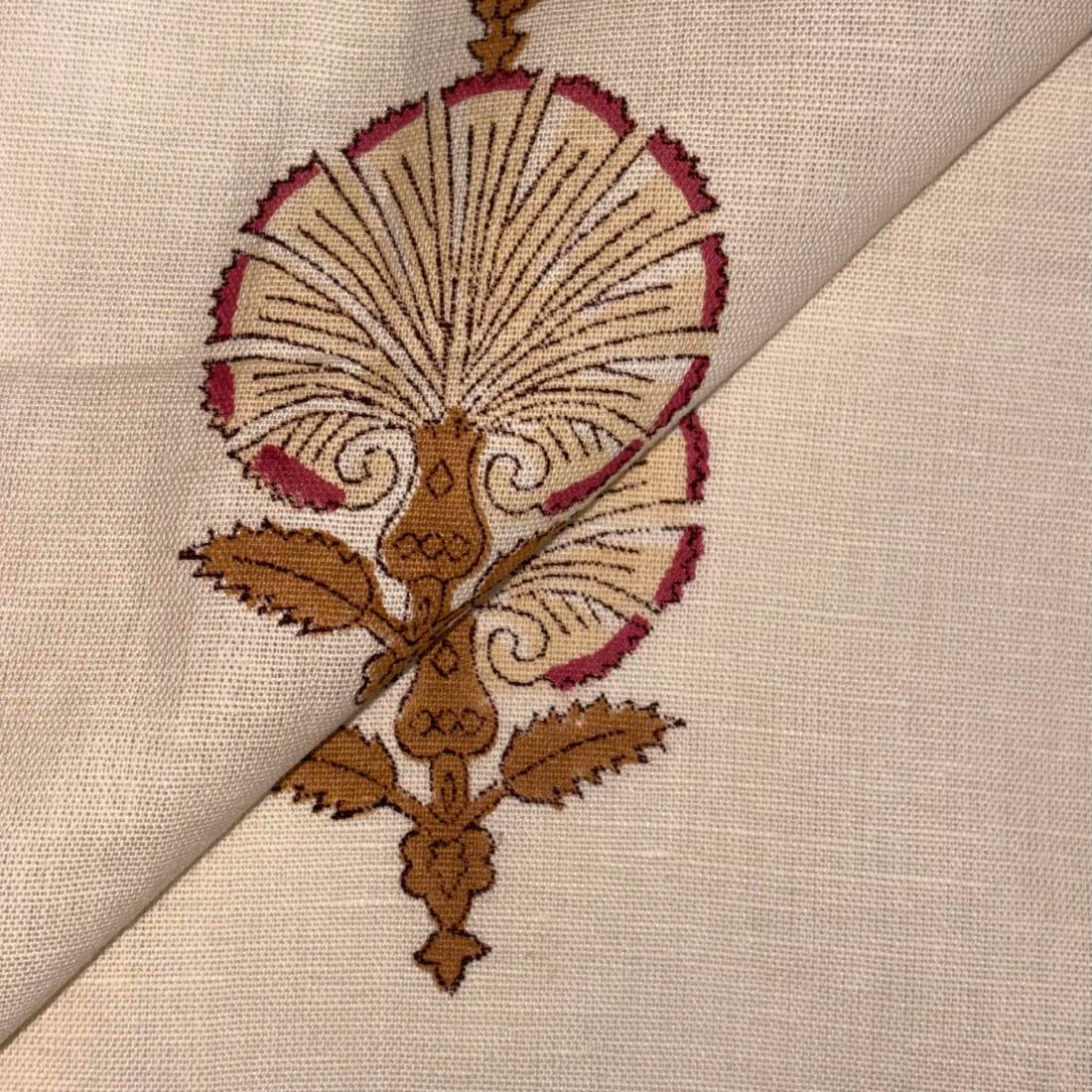 Close-up of intricate embroidery on fabric with brown and red thread
