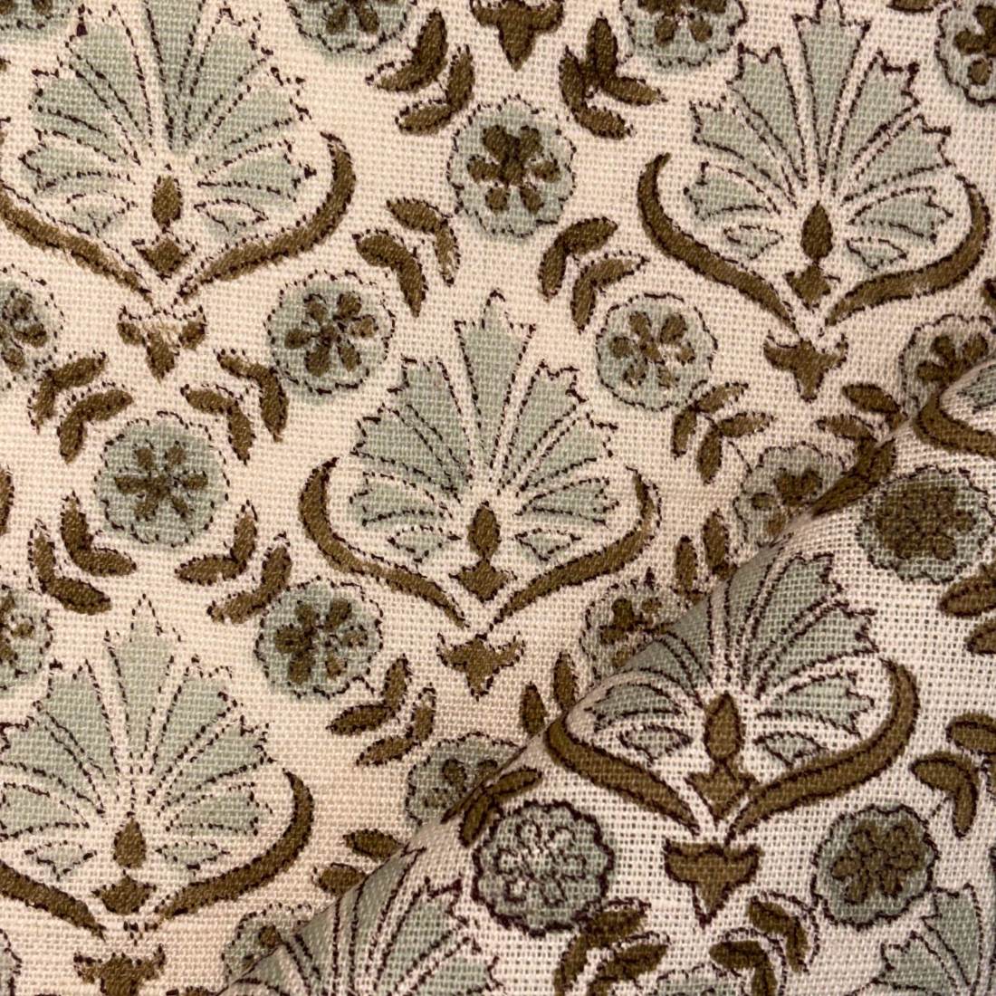 Decorative fabric pattern with floral and leaf designs in brown and green on a beige background