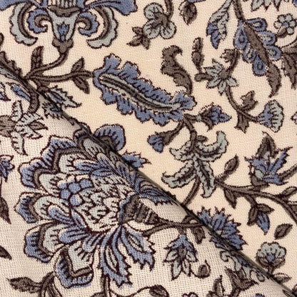 Close-up of floral fabric pattern with blue and brown colors on a beige background