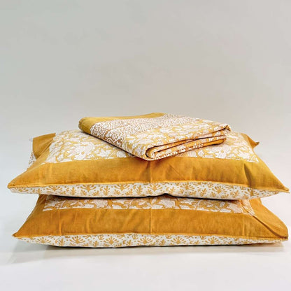Mustard yellow bedding set with floral patterns on a white background