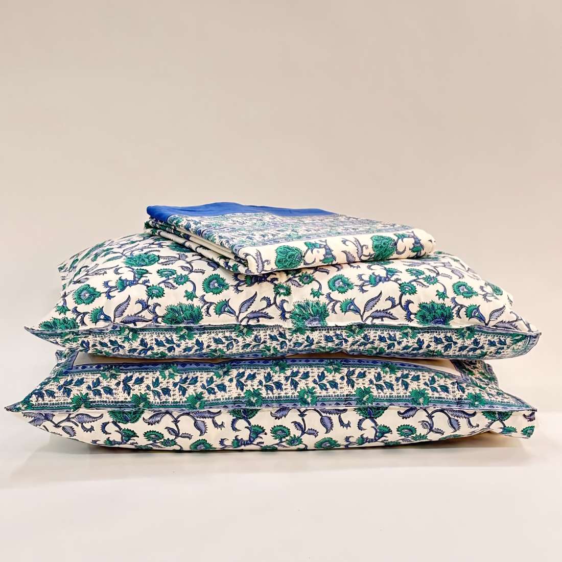 Stack of floral-patterned pillows on a plain background