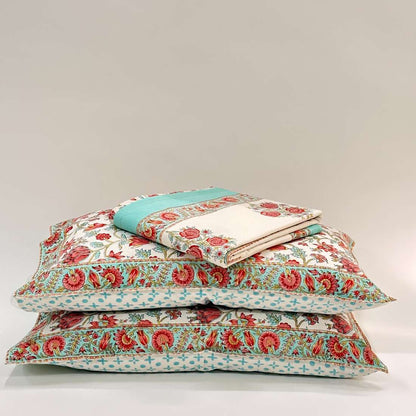 Stack of floral-patterned pillows on a light gray background