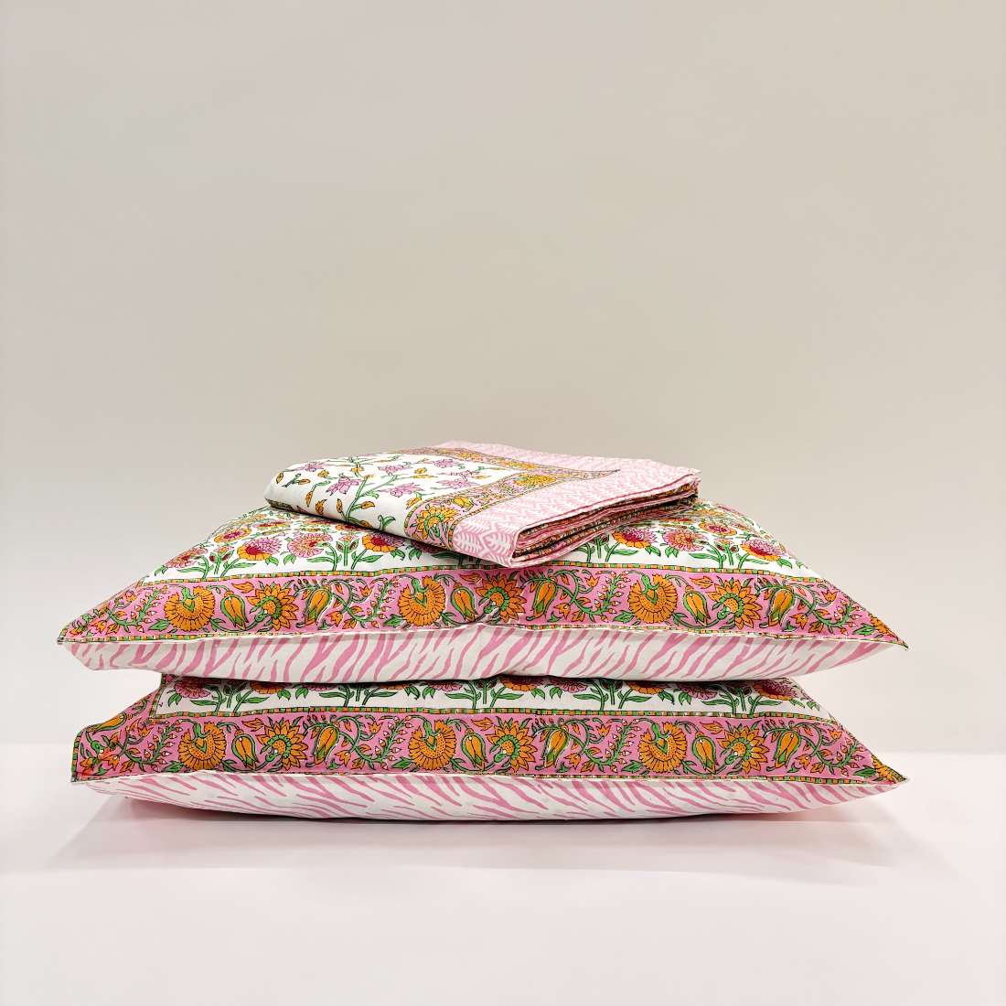 Stack of patterned pillows on a light background