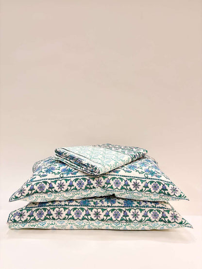 Stack of floral-patterned pillows on a beige background