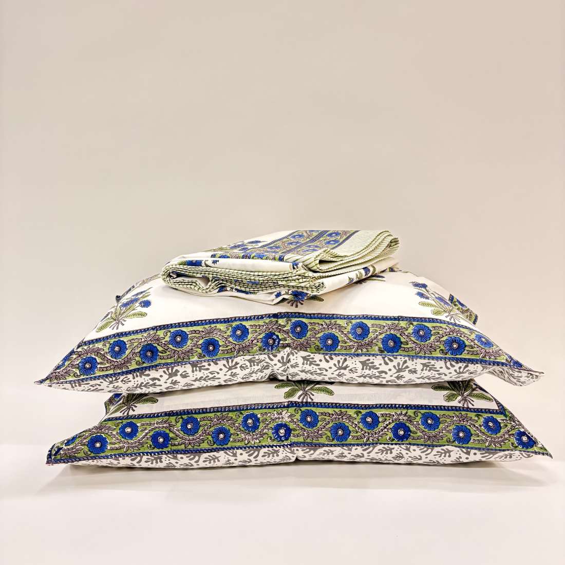 Stack of pillows with blue and green patterns on a white background