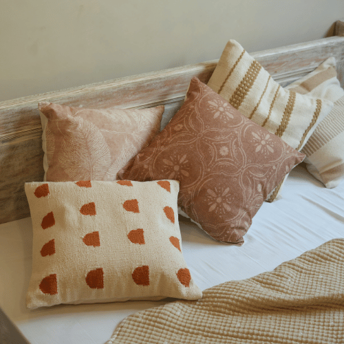 Patterned pillows on a bed with a neutral background