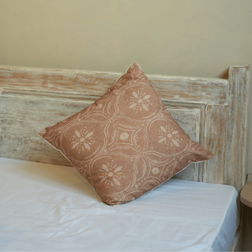 Patterned pillow on a bed with a wooden headboard