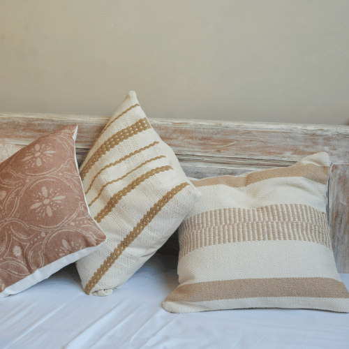 Three decorative pillows with patterns on a wooden surface.