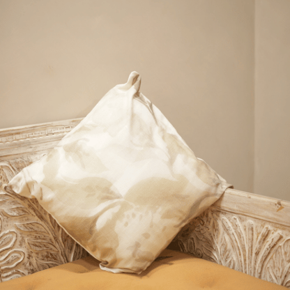 Beige pillow on a textured beige sofa against a plain wall