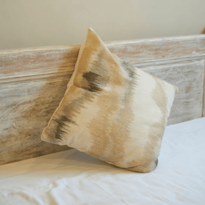 Beige pillow on a wooden headboard with white bedding