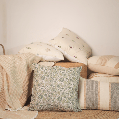Stack of decorative pillows with floral patterns on a neutral background