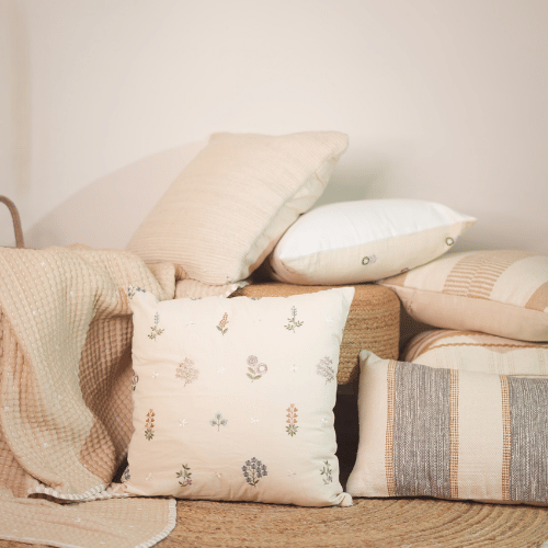 Collection of decorative pillows on a sofa with a neutral color palette.