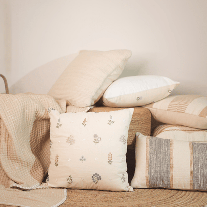 Collection of decorative pillows on a sofa with a neutral color palette.
