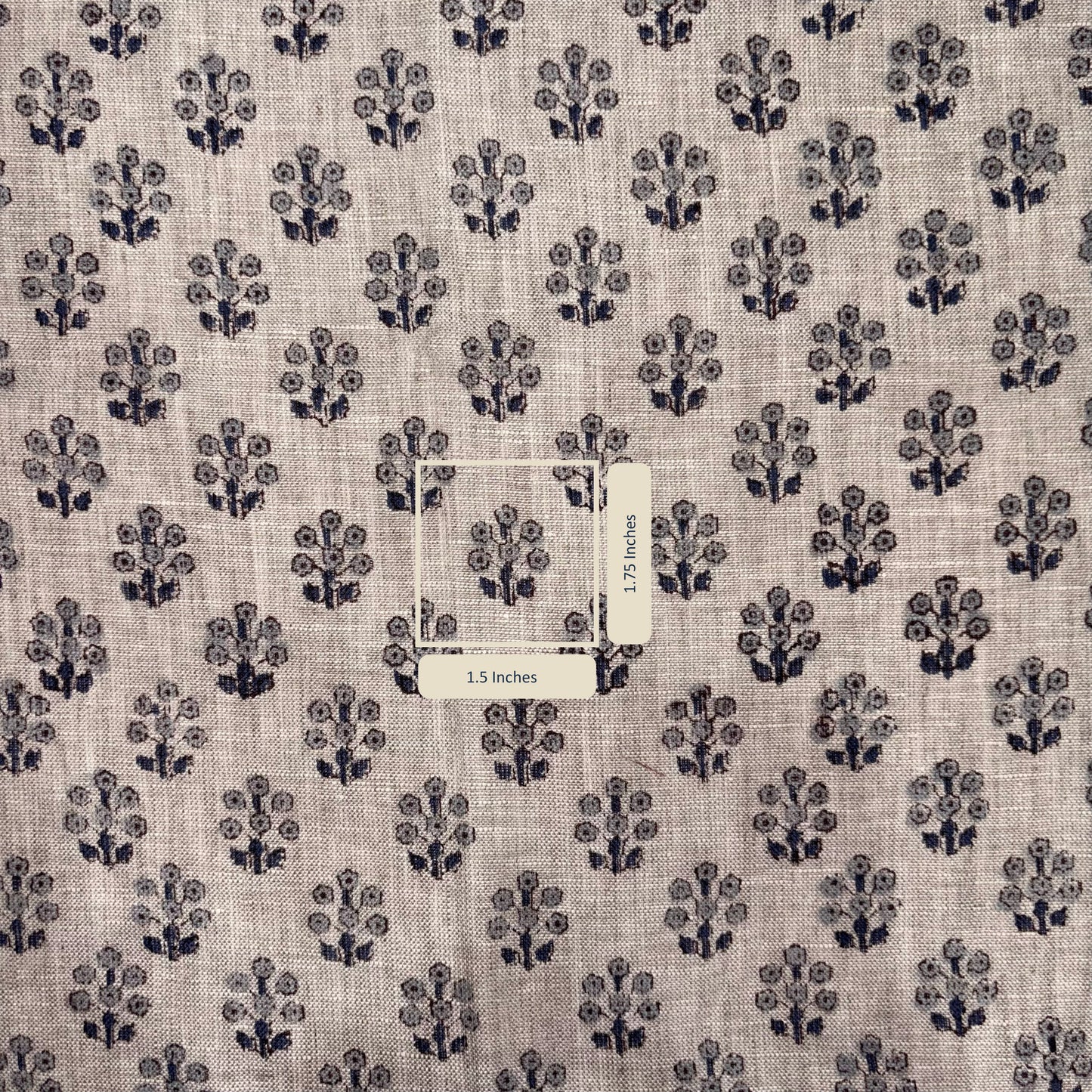 Fabric with a subtle pattern of small black floral designs on a grey background, with a label in the center.
