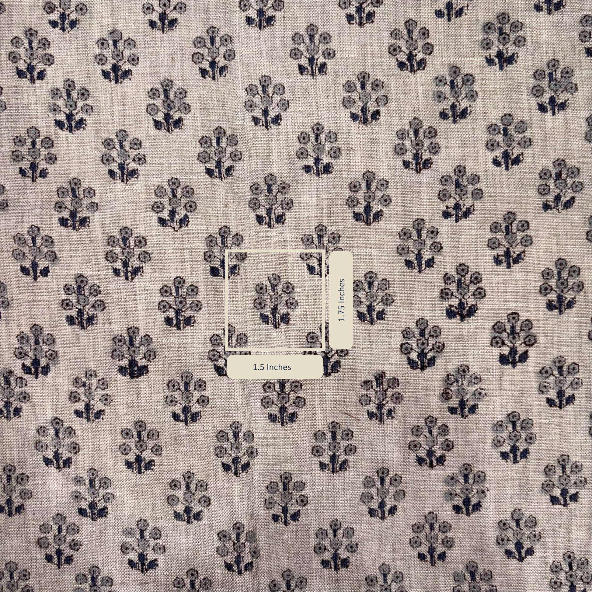 Fabric with a subtle pattern of small black floral designs on a grey background, with a label in the center.