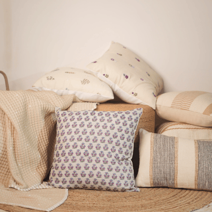 Collection of patterned pillows on a textured surface with a neutral background