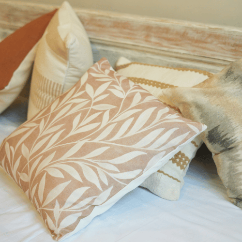 Decorative pillows with leaf pattern on a bed