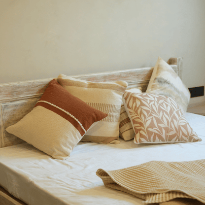 Bed with decorative pillows and a blanket in a cozy bedroom setting