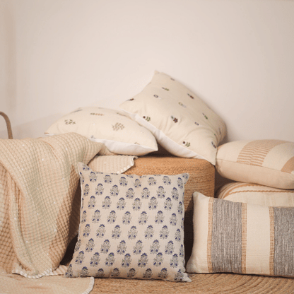 Collection of patterned cushions on a textured surface with a neutral background