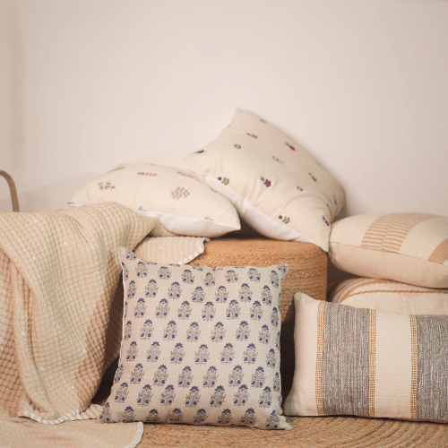 Collection of patterned cushions on a textured surface with a neutral background