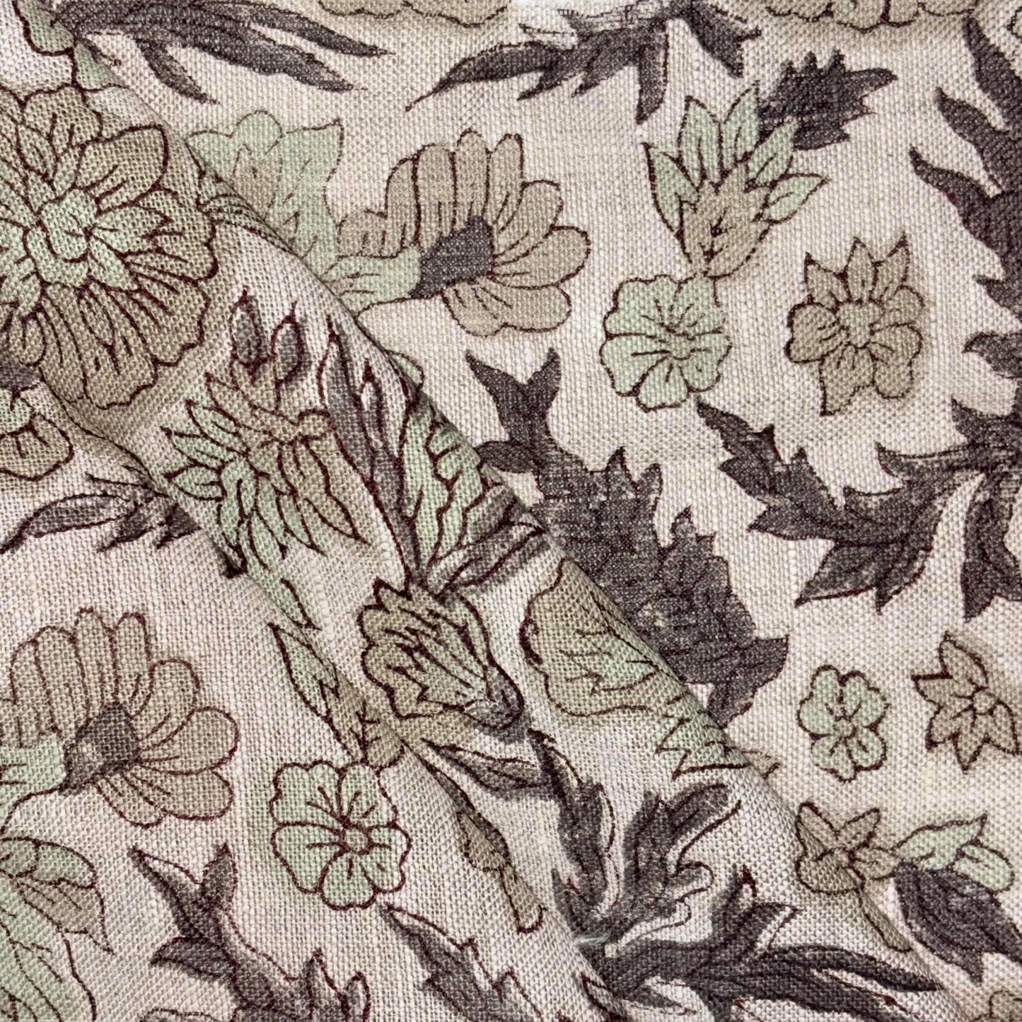 Close-up of floral fabric pattern with green and brown colors on a grey background