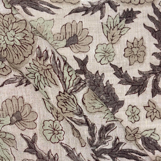 Close-up of floral fabric pattern with green and brown colors on a grey background