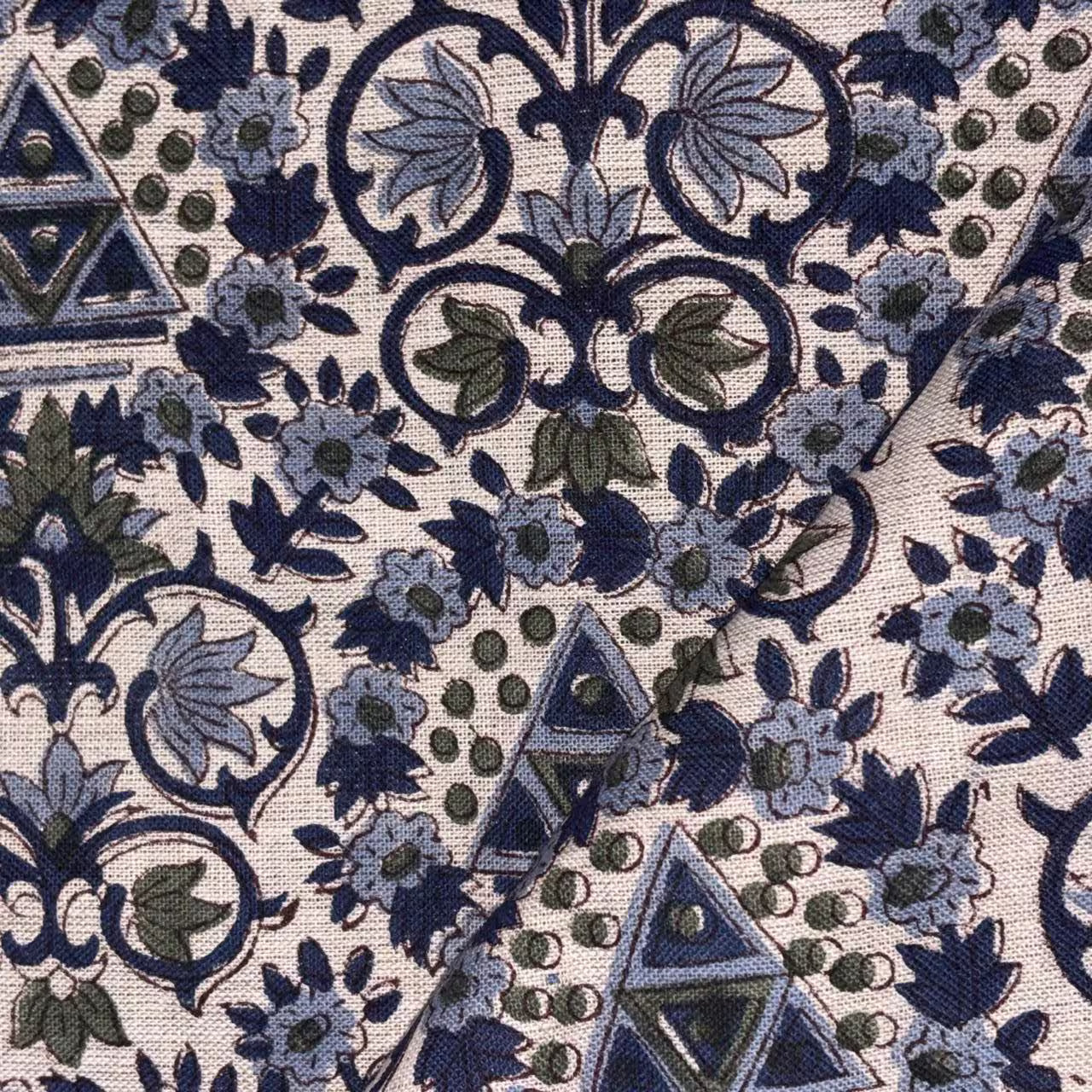 Close-up of a patterned fabric with blue and green designs on a green background