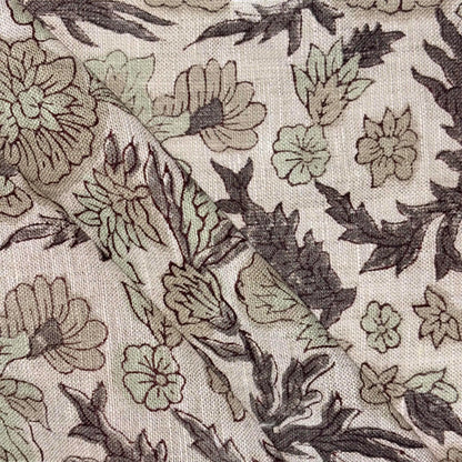 Close-up of floral fabric pattern with green and brown colors on a grey background