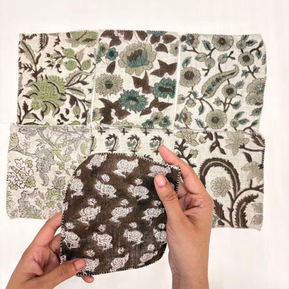 A set of six square fabric swatches with various botanical and floral patterns in brown, green, beige, and blue on an off-white background, arranged in a grid.